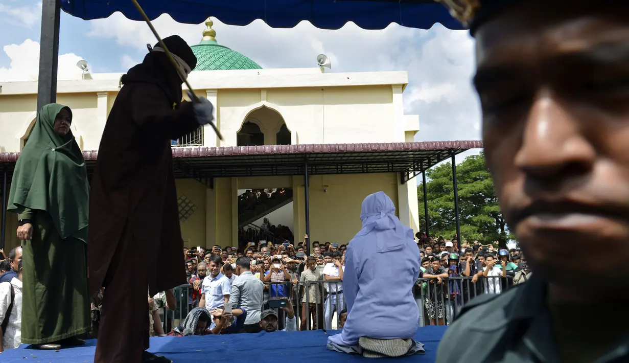 Seorang wanita berusia 19 tahun menjalani hukuman cambuk di depan umum di Banda Aceh (31/1). Dua remaja AS laki-laki (19) dan NS perempuan (19) dicambuk setelah mereka ketahuan berpelukan di depan umum. (AFP Photo/Chaideer Mahyudin)