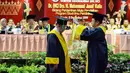 Rektor Universitas Negeri Padang (UNP) Ganefri saat menganugerahkan gelar doktor kehormatan (Dr. Honoris Causa) kepada Mantan Wakil Presiden Jusuf Kalla di kampus tersebut di Padang, Kamis (5/12/2019). JK menerima anugerah doktor honoris causa di bidang penjamin mutu pendidikan. (FOTO: Tim Media JK)