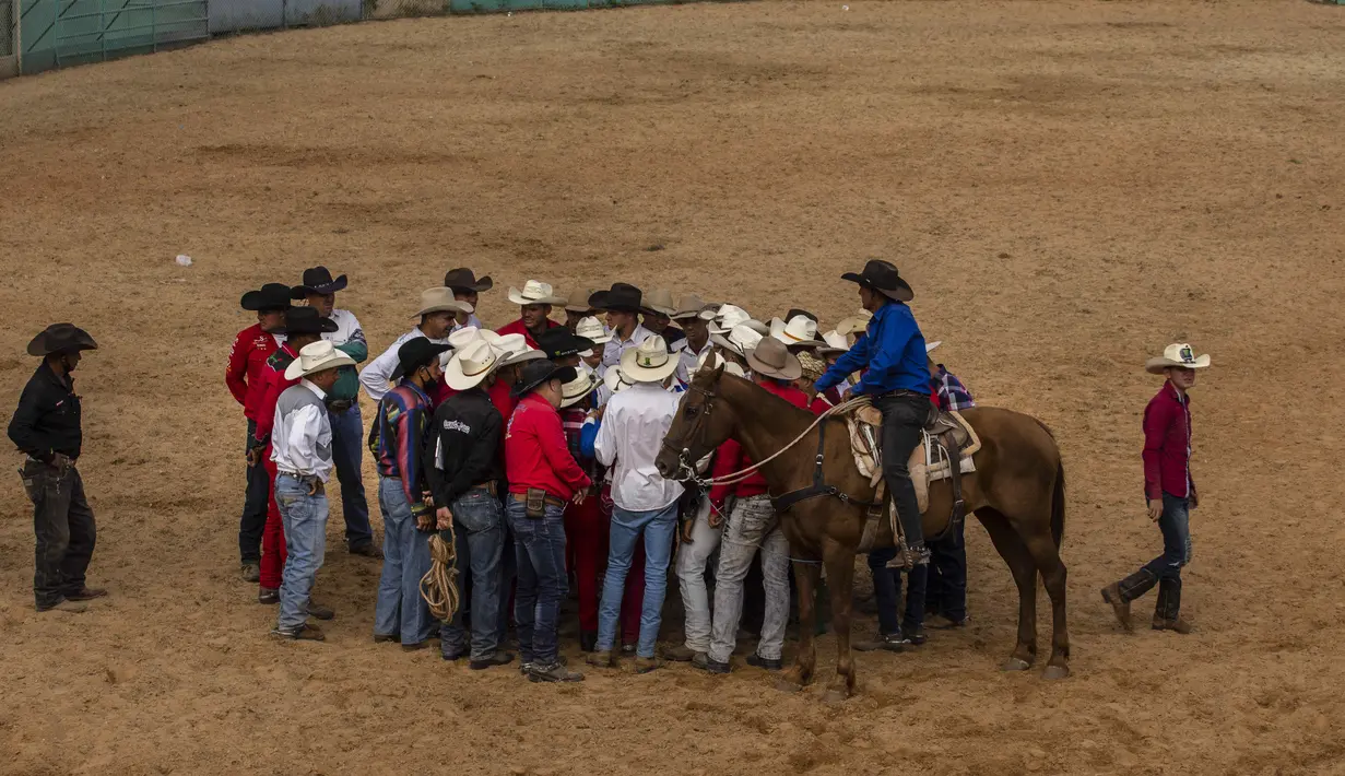 Koboi berkumpul untuk berbicara setelah kompetisi di rodeo adil Peternak Boyeros di Pameran Pertanian Internasional Fiagrop 2022 di Havana, Kuba (8/4/2022). Rodeo di Kuba adalah tradisi yang berusia lebih dari dua abad. (AP Photo/Ramon Espinosa)