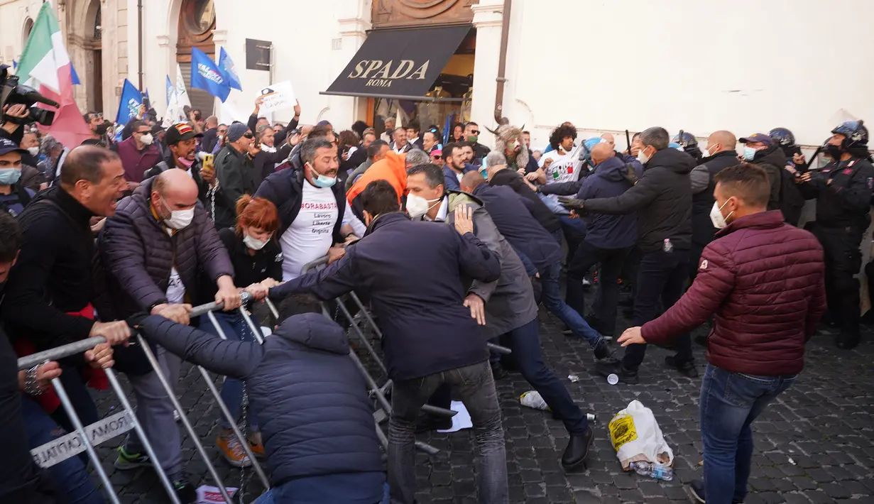 Demonstran bentrok dengan polisi Italia saat aksi protes oleh pemilik Restoran dan toko di luar lower Chamber di Roma, Selasa (6/4/202). Demonstran menuntut pembukaan kembali bisnis mereka dan memprotes tindakan pembatasan untuk mengatasi lonjakan kasus COVID-19. (AP Photo/Andrew Medichini)