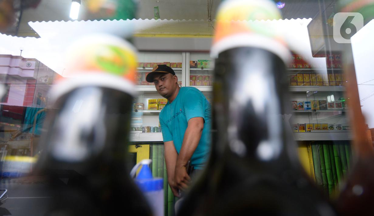 Hendri (37) membersihkan toko jamu aduk miliknya di kawasan Pamulang, Tangerang Selatan, Banten, Senin (28/9/2020). Menurutnya penjualan jamu aduk pada masa musim pandemi Covid 19 satu bulan ini penjualan meningkat hingga 200 persen dibandingkan bulan sebelumnya. (merdeka.com/Dwi Narwoko)
