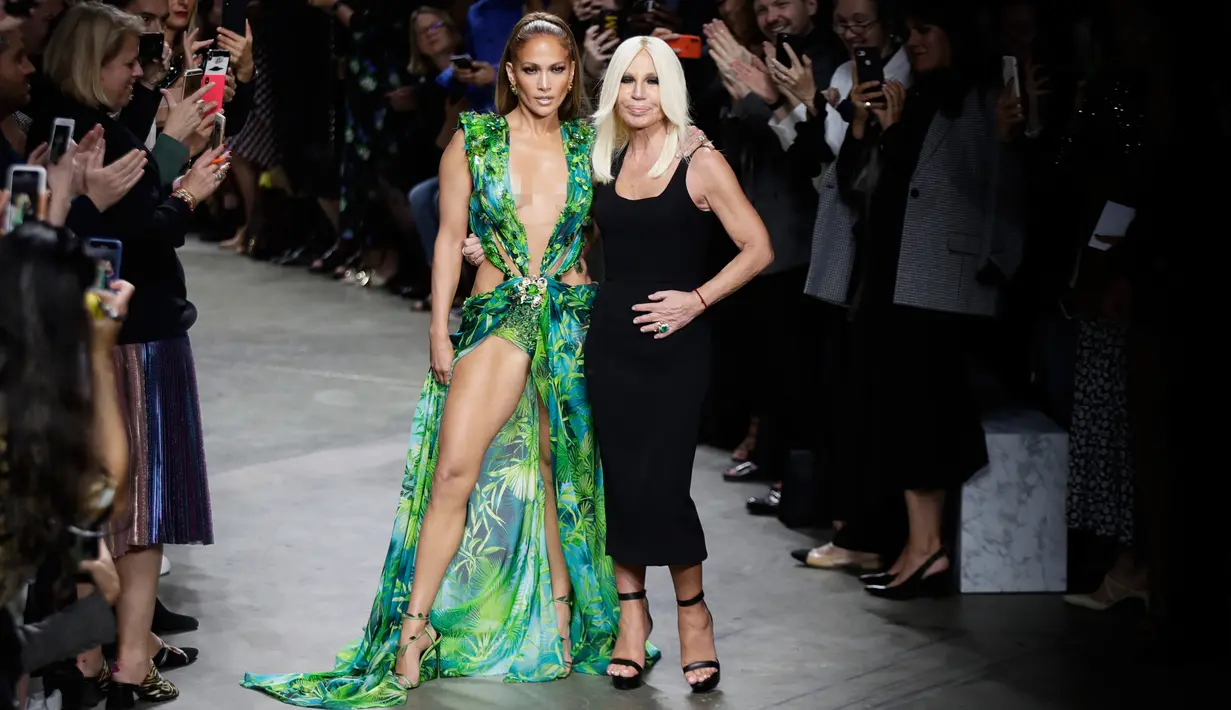 Jennifer Lopez dan desainer, Donatella Versace berpose bersama usai peragaan busana Versace untuk Spring/Summer Collection 2020 pada Milan Fashion Week 2019, Jumat (20/9/2019). J.Lo mengenakan versi baru gaun hijau ikonis yang pernah ia gunakan di Grammy Awards 20 tahun lalu. (AP/Luca Bruno)