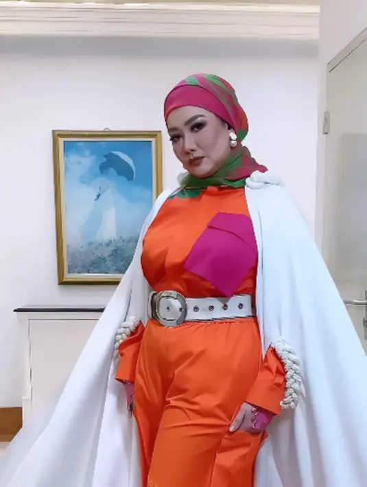 Gaya nyentrik Reza dalam balutan busana modest karya Donna Prive x Carendelano. Penampilannya dilengkapi dengan hijab turban warna senada.  [@rezaartameviaofficial]
