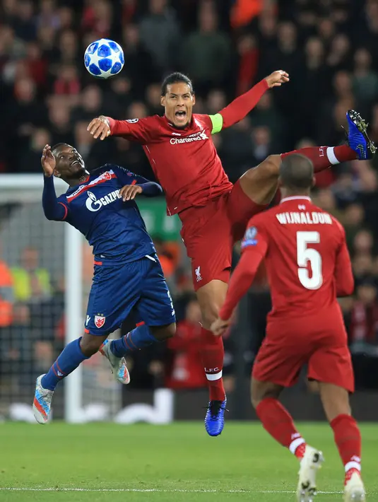 Bek Liverpool, Virgil Van Dijk berebut bola dengan pemain Red Star Belgrade, El Fardou Ben Nabouhane selama pertandingan grup C Liga Champions di stadion Anfield, Inggris (24/10). Liverpool menang telak 4-0 atas Red Star. (AP Photo/Jon Super)