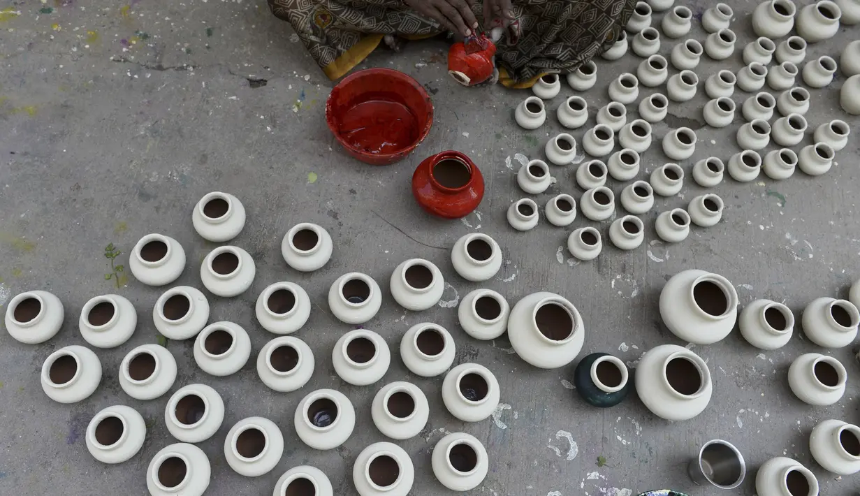 Perajin mewarnai pot minyak tembikar atau diyas menjelang Diwali, festival lampu Hindu, di sebuah lokakarya di Hyderabad (4/11/2020). Perayaan Diwali tiap tahunnya jatuh antara bulan Oktober atau November. (AFP Photo/Noah Seelam)