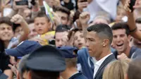 Cristiano Ronaldo saat menyapa suporter Juventus saat tiba di pusat layanan kesehatan Juventus (J-Medical), Turin, Italia, (16/7). Ronaldo akan mengenakan nomor punggung 7, seperti yang dikenakannya di Real Madrid. (AP Photo/Luca Bruno)