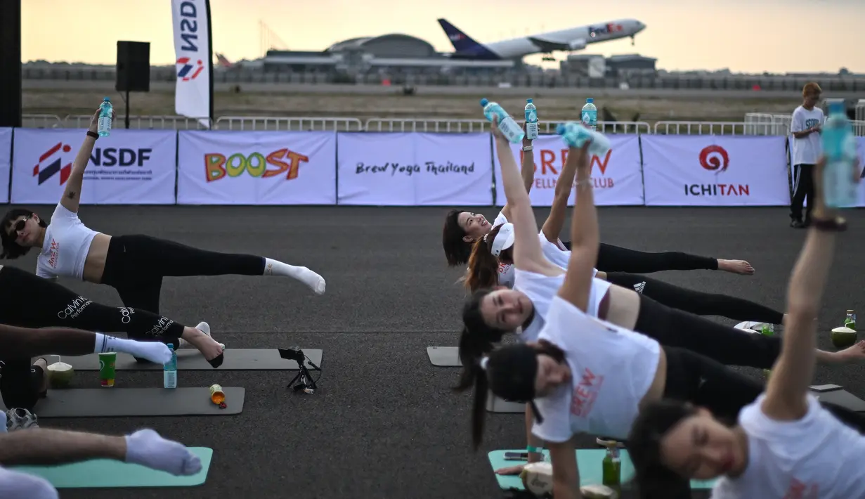 Sebagian besar dari mereka mengenakan seragam yoga berupa legging hitam dan kaos putih berpotongan pendek - dalam hal ini bertuliskan kata "BREW" untuk Brew Yoga yang menyelenggarakan acara tersebut. (MANAN VATSYAYANA / AFP)