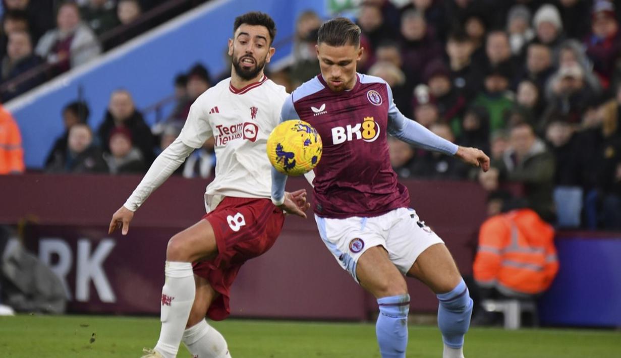 Pemain Manchester United, Bruno Fernandes, berebut bola dengan pemain Aston Villa, Matty Cash, pada laga pekan ke-24 Premier League 2023/2024 di Villa Park, Minggu (11/02/2024). (AP Photo/Rui Vieira)