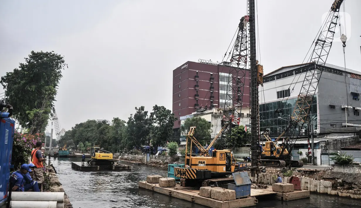 Pekerja dari Dinas Sumber Daya Air (SDA) Provinsi DKI Jakarta menggunakan kendaraan alat berat saat menyelesaikan proyek normalisasi Kali Ciliwung di Jalan Gunung Sahari, Jakarta Pusat, Senin (22/8/2022). Pemprov DKI Jakarta melalui Dinas SDA memastikan program normalisasi Kali Ciliwung terus berjalan dengan prioritas di lokasi aliran utama sungai dan tujuh kelurahan yang merupakan titik rawan banjir. (merdeka.com/Iqbal S. Nugroho)