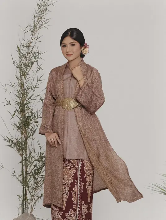 Erina Gudono tak pernah gagal memesona. Di sini ia padukan outfitnya yang kental dengan nuansa wastra. Atasan cokelat dipadunya dengan kain batik merah bata sebagai rok dan outer lace yang serasi. [Foto: Instagram/erinagudono]