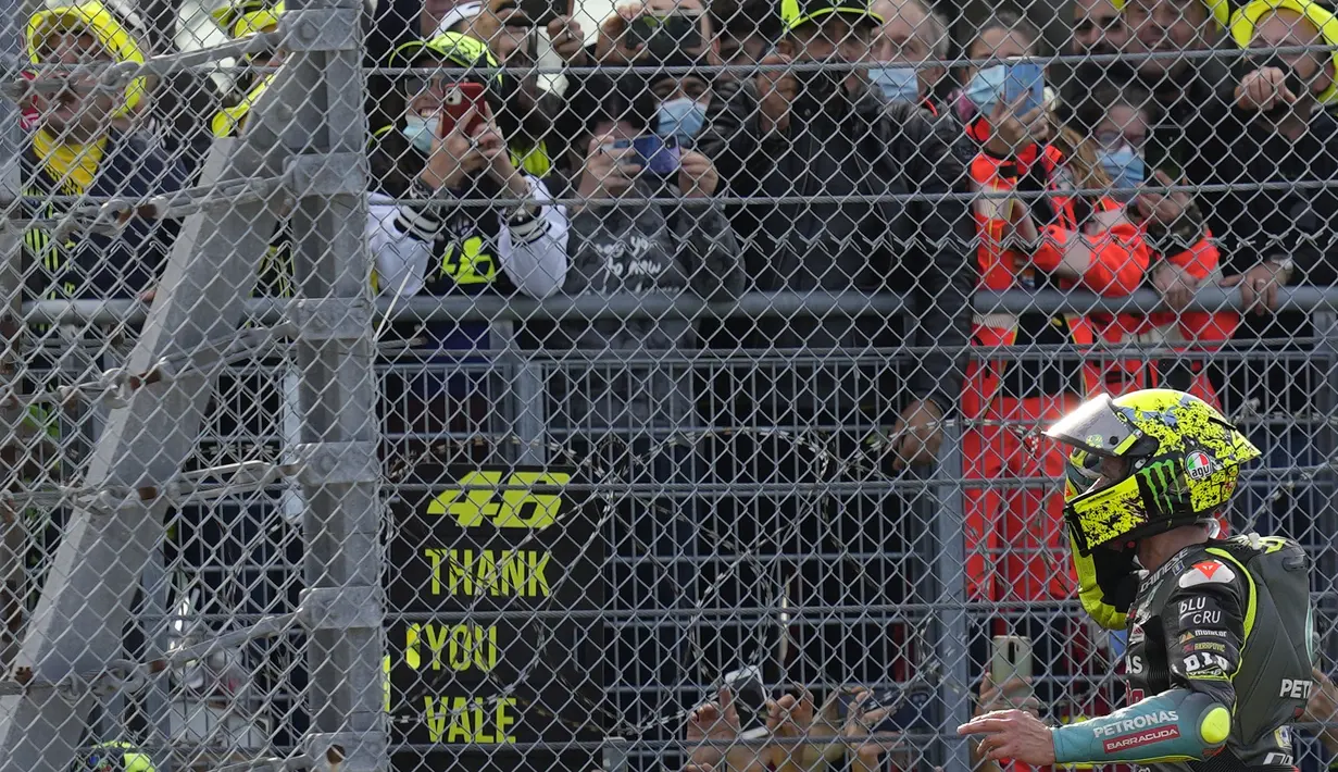 Pembalap Petronas Yamaha SRT, Valentino Rossi, melambaikan tangan kepada para penggemarnya di akhir balapan MotoGP Emilia Romagna di sirkuit Misano, Minggu (24/10/2021). MotoGP Emila Romagna menjadi balapan terakhir Rossi di tanah kelahirannya, Italia. (AP Photo/Antonio Calanni)