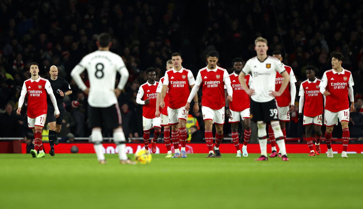 <p>Para pemain Manchester United menunggu para pemain Arsenal yang baru saja merayakan gol yang dicetak Bukayo Saka dalam laga pekan ke-21 Premier League di Emirates Stadium, Minggu (22/1/2023). Arsenal menang 3-2 atas MU. (AP Photo/Ian Walton)</p>