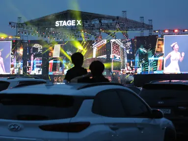 Orang-orang menyaksikan konser drive-in Stage X dari dalam mobil di sebuah tempat parkir di Goyang, Korea Selatan, 23 Mei 2020. Tujuan konser ini untuk memberikan hiburan bagi warga Korea Selatan yang mendambakan acara-acara musik yang ditangguhkan selama pandemi Covid-19. (AP Photo/Ahn Young-joo)
