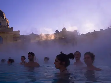 Pengunjung menikmati bersantai sambil berendam di kolam air panas Szechenyi Thermal Bath di Budapest, Hongaria, 7 Januari 2017. Szechenyi Thermal Bath adalah salah satu lokasi pemandian umum tertua dan terbesar di Budapest. (Bea Kallos/MTI via AP)