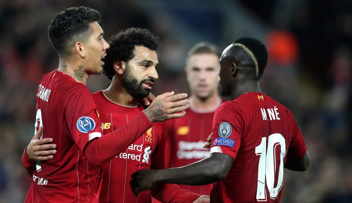 Pemain Liverpool Mohamed Salah (tengah) merayakan golnya ke gawang Red Bull Salzburg bersama Sadio Mane (kanan) dan Roberto Firmino (kiri) pada lanjutan Liga Champions di Stadion Anfield, Liverpool, Inggris, Rabu (2/10/2019). The Reds menang tipis 4-3 atas Salzburg. (AP Photo/Jon Super)