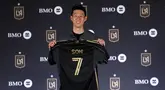 Pemain baru Los Angeles Lakers, Son Heung-min berfoto dengan memegang jersey miliknya dalam acara konferensi pers di BMO Stadium, Los Angeles, Amerika, Rabu (06/08/2025) waktu setempat. (AFP/Getty Images/Kevork Djansezian)
