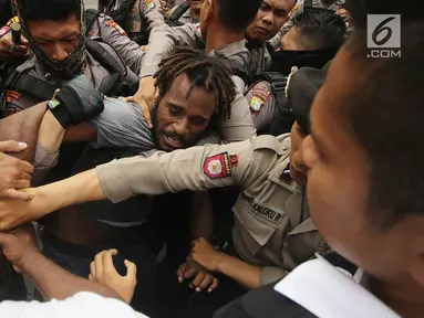 Massa yang tergabung dalam Front Rakyat Indonesia untuk West Papua (FRI-WP) dan Aliansi Mahasiswa Papua (AMP) terlibat aksi saling dorong dengan polisi saat unjuk rasa di Jalan Medan Merdeka Barat, Jakarta, Selasa (15/8). (Liputan6.com/Immanuel Antonius)