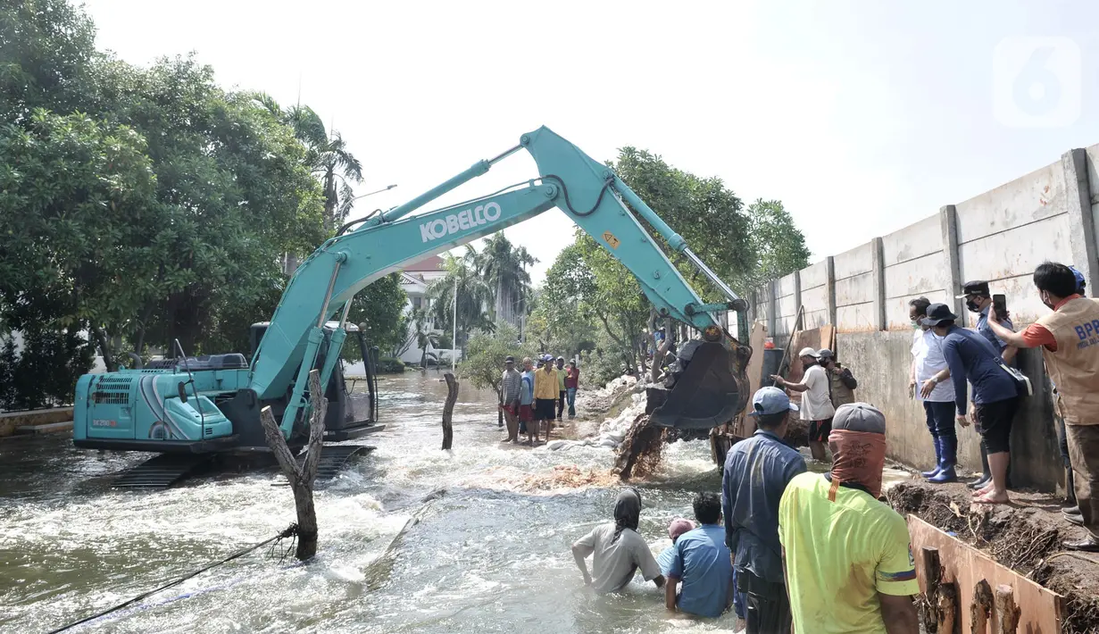 Pekerja menggunakan kendaraan alat berat saat menyelesaikan perbaikan tanggul jebol di Kompleks Perumahan Pantai Mutiara, Pluit, Jakarta, Minggu (7/6/2020). (Liputan6.com/Iqbal S. Nugroho)