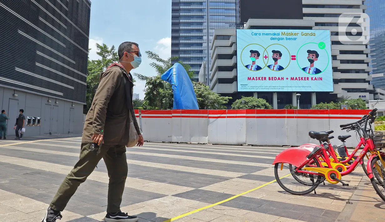Warga berjalan dekat proyek pembangunan Tugu Sepeda di  kawasan Jenderal Sudirman, Jakarta, Rabu (22/9/2021). Dinas Perhubungan DKI Jakarta memastikan pembangunan Tugu Sepeda masih berlanjut, dan pembangunnya hingga saat ini telah mencapai 90 persen. (Liputan6.com/Herman Zakharia)
