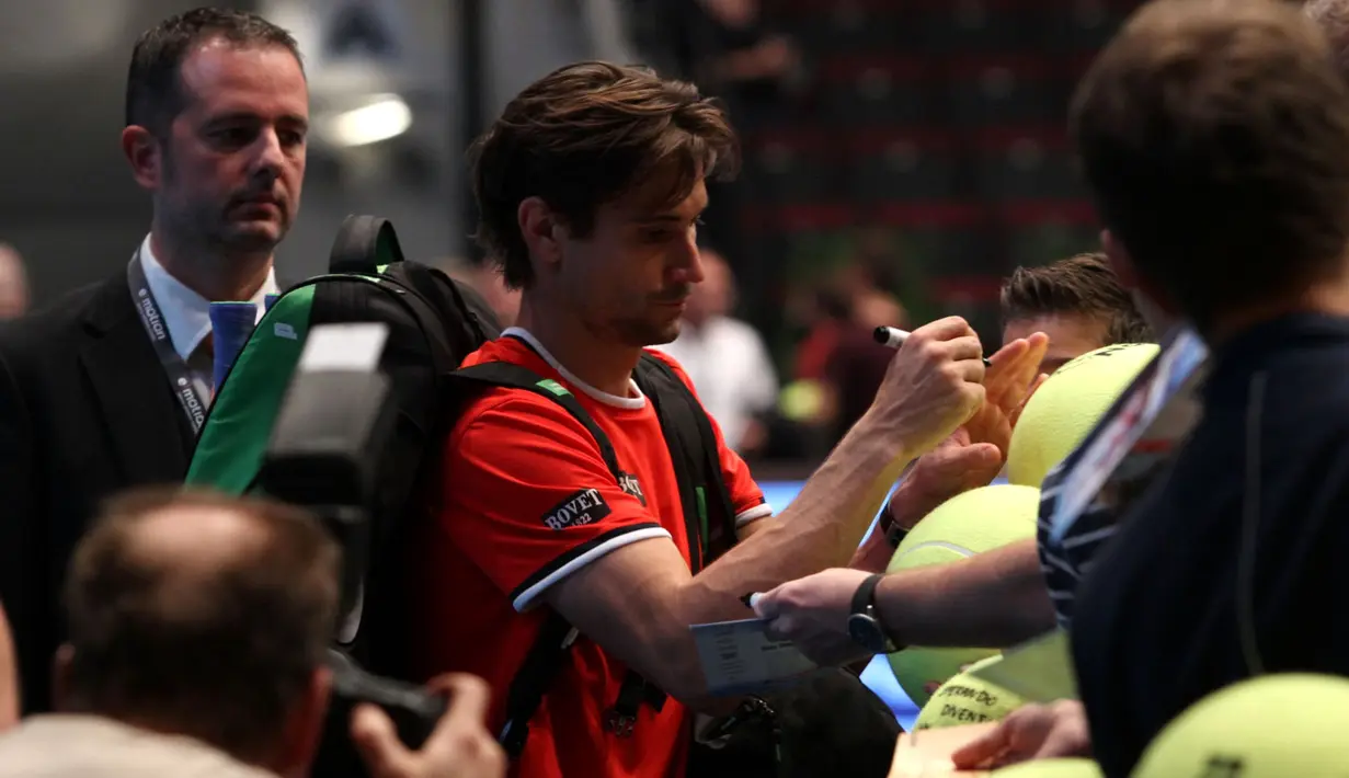David Ferrer melayani permintaan tanda tangan dari puluhan fans yang antre di pintu masuk arena pertandingan di Stadthalle Arena, Minggu, (25/10/2015) malam WIB. (Bola.com/Reza Khomaini)
