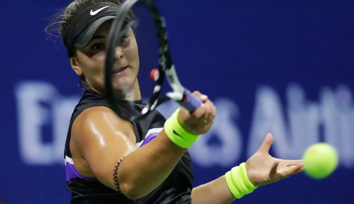 Petenis Kanada, Bianca Andreescu melakukan servis ke arah petenis Swiss, Belinda Bencic pada babak semifinal AS Terbuka di Arthur Ashe Stadium, Kamis (6/9/2019). Petenis berusia 19 tahun itu mengamankan tiket ke final usai menang dengan skor 7-6 (7-3) dan 7-5. (AP/Adam Hunger)