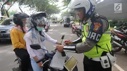 Anggota Satlantas Polres Tangerang Selatan memeriksa kelengkapan surat saat razia pajak kendaraan di Jalan BSD, Tangerang Selatan, Kamis (24/1). Razia juga untuk meningkatkan tertib lalu lintas dan disiplin pengendara bermotor. (Merdeka.com/Arie Basuki)