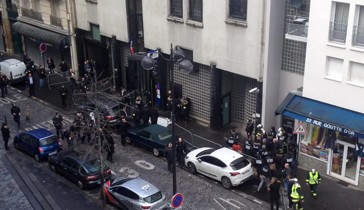 Polisi memeriksa jasad seorang pria yang ditembak mati di sebuah kantor polisi di Paris, Prancis, Kamis (7/1). Pria itu ditembak mati karena memaksa masuk ke kantor polisi dengan mengenakan rompi peledak. (Handout via Social Media Website/Anna Polonyi)