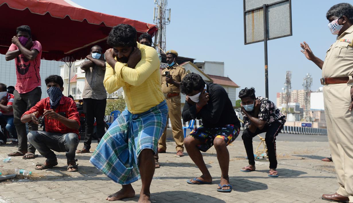 Orang-orang dipaksa untuk melepas alas kaki sebagai hukuman karena karena keluar rumah selama pemberlakukan penguncian wilayah (lockdown) di Chennai, Rabu (1/4/2020). Pemerintah India menerapkan kebijakan karantina wilayah atau lockdown dalam memerangi Virus Corona COVID-19. (Arun SANKAR / AFP)