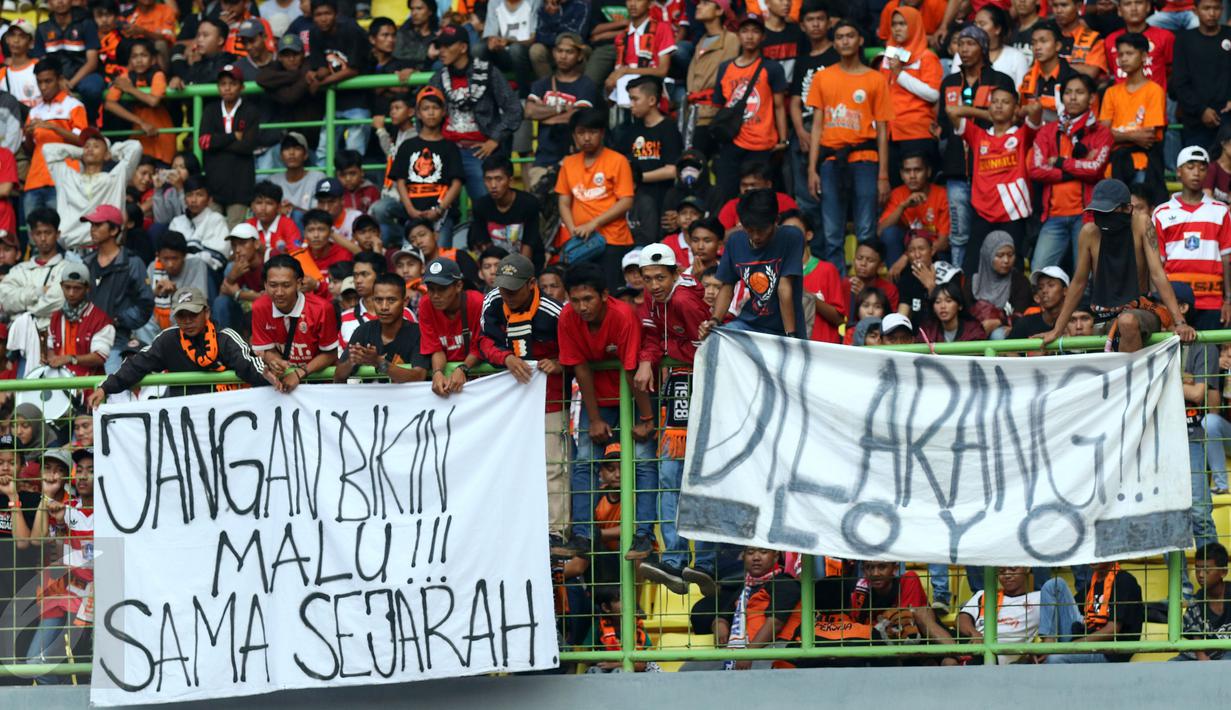 Suporter membentangkan spanduk protes usai menyaksikan laga Persija melawan Mitra Kukar pada lanjutan Liga 1 Indonesia di Stadion Patriot Candrabhaga, Bekasi, Minggu (14/5). Laga kedua tim berakhir imbang 1-1. (Liputan6.com/Helmi Fithriansyah)