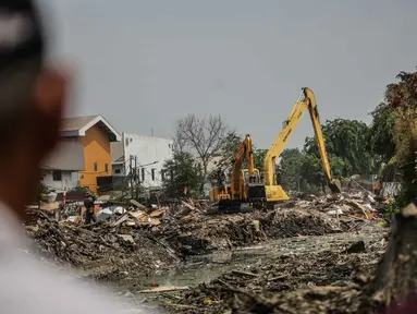 Warga melihat pembongkaran bangunan liar yang berada di dekat kali kecil di kawasan Jalan Agung Perkasa VIII Sunter, Jakarta, Senin (18/11/2019). Pembongkaran tersebut ditujukan untuk menciptakan tata ruang ramah lingkungan dan sehat. (Liputan6.com/Faizal Fanani)