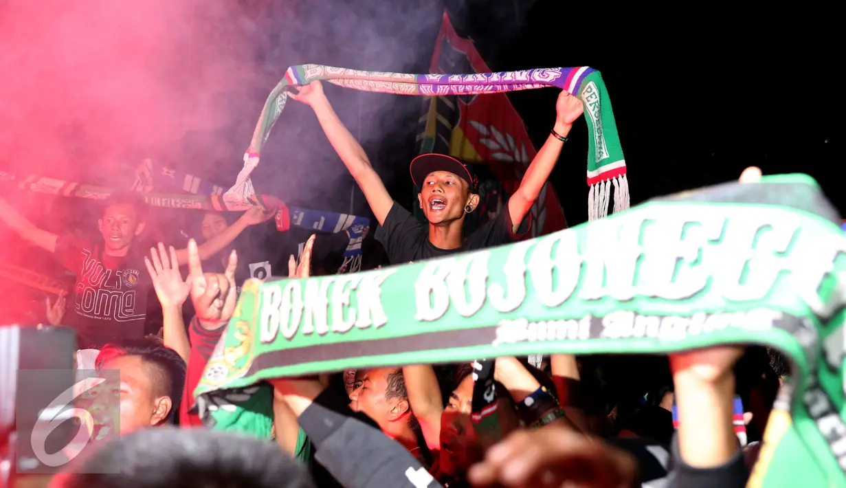 Pendukung Persebaya mengangkat syal saat bernyanyi di GOR Padjajaran, Bandung, Sabtu (7/1). Ribuan suporter Persebaya berkumpul di GOR Padjajaran menunggu keputusan kongres PSSI terkait nasib klub kesayangan mereka. (Liputan6.com/Helmi Fithriansyah)