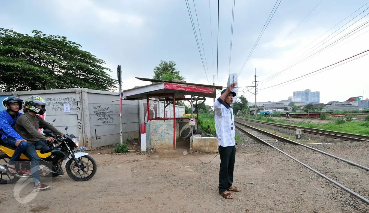 Akibat tidak adanya penjaga perlintasan kereta api, Muhamad Ali warga Pondok Cina berinisiatif untuk mejaga pos jaga perlintasan kereta api yang dibuat secara swadaya, Depok, Minggu (13/12/2015). (Liputan6.com/Yoppy Renato)