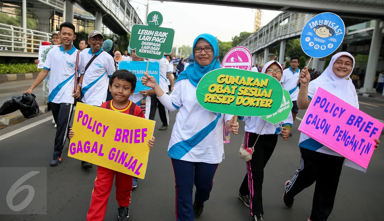 Para peserta jalan sehat di Monas membawa berbagai macam atribut yang mengajak untuk berperilaku hidup sehat, Jakarta, Minggu (6/12/2015). Acara tersebut dihadiri sebanyak 2000 peserta. (Liputan6.com/Faizal Fanani)