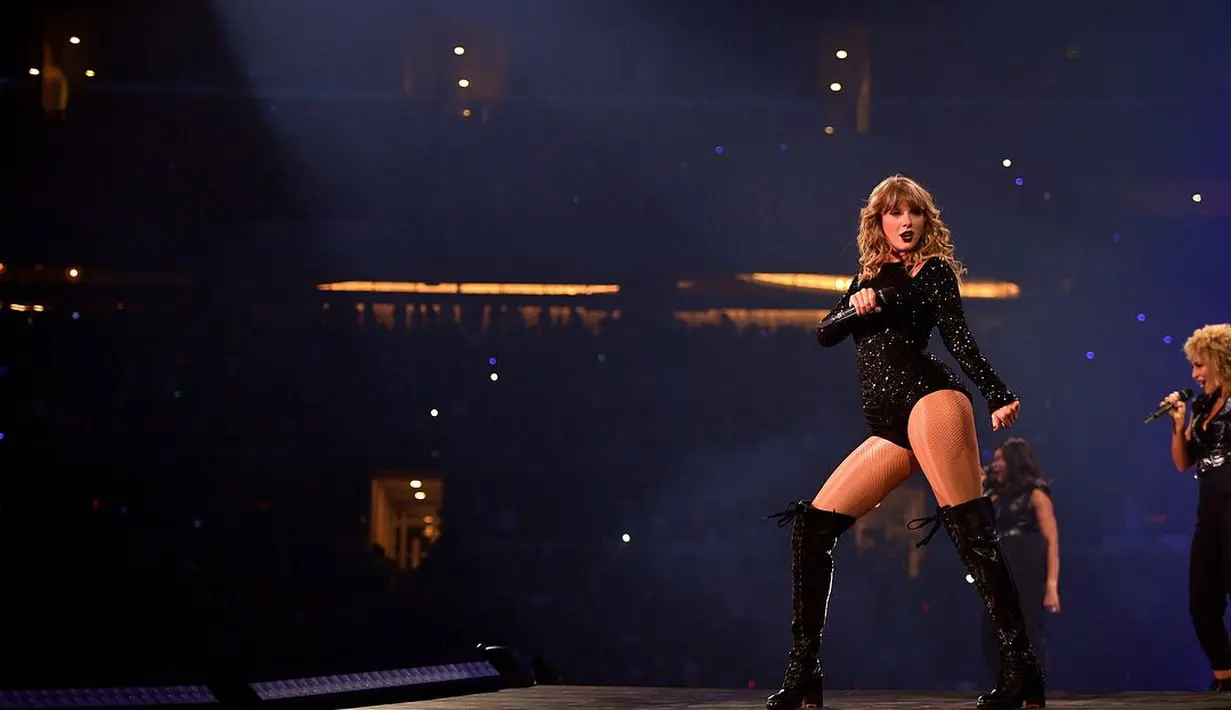 Saat konser di AT&T Stadium, Taylor Swift mengenakan bodycon sequin berwarna hitam dengan potongan lengan panjang. Outfit ini dipadukan dengan high tight boots yang membuat penampilannya terlihat fearless.