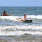 Surfing termasuk aktivitas wisata air yang sangat populer di Bali. Disana banyak pantai yang memiliki ombak dan arus yang sangat bagus untuk berselancar. (Bola.com/M iqbal Ichsan)