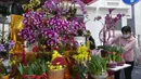 Seorang perempuan mempersiapkan bunga untuk dijual di pasar untuk merayakan Tahun Baru Imlek di Hong Kong, Minggu (30/1/2022). Tahun Baru China atau Imlek jatuh pada 1 Februari (AP Photo/Vincent Yu)