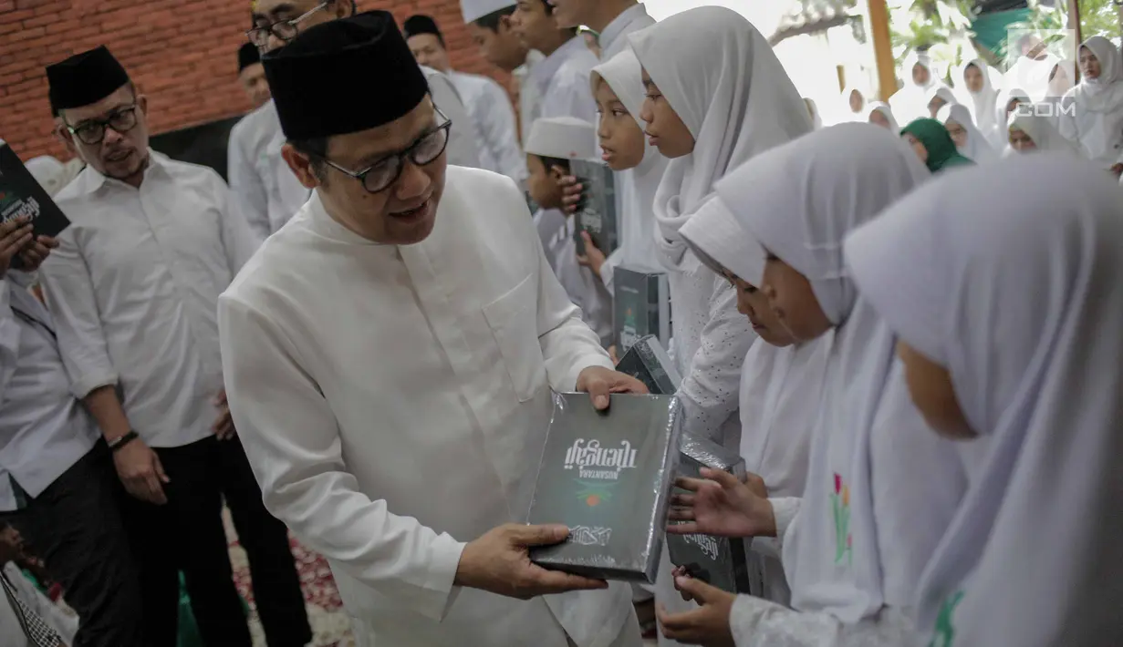 Inisiator gerakan Nusantara Mengaji Muhaimin Iskandar membagikan buku kepada anak-anak saat membuka Nusantara Bertauhid di Ciganjur, Jakarta, Kamis (14/3). Acara ini mengusung tema 'Khataman Alquran untuk Persatuan Indonesia'. (Liputan6.com/Faizal Fanani)