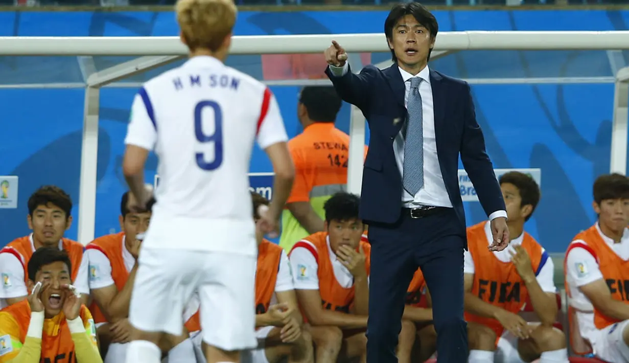 Pelatih Timnas Korea Selatan, Myung Bo Hong (kanan) memberikan instruksi kepada pemainnya, Heung Min Son, saat berlaga di babak penyisihan Piala Dunia 2014 Grup H, Pantanal Arena, Cuiaba, Brasil, (18/6/2014). (REUTERS/Eddie Keogh)