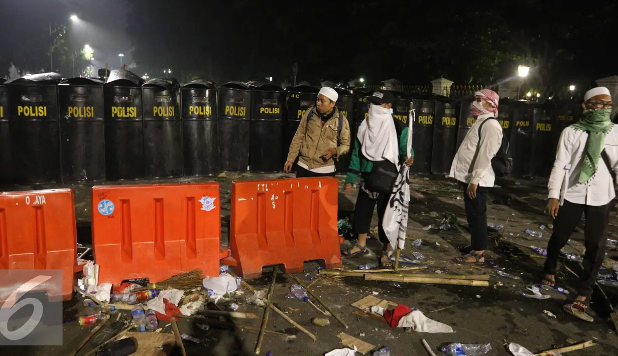 Polisi berjaga di jalan Medan Merdeka Barat saat Aksi Damai 4 November, Jakarta, Jumat (4/11). Polisi membubarkan massa dengan paksa dengan gas air mata. (Liputan6.com/Faizal Fanani)