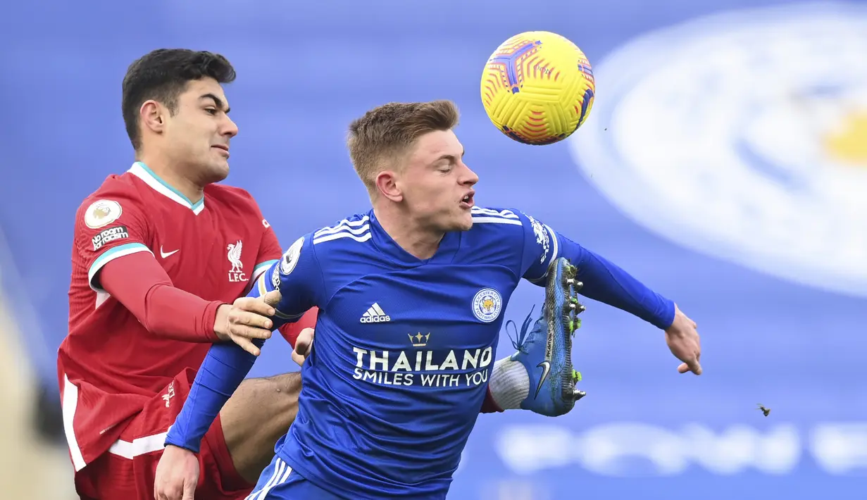 Bek Liverpool, Ozan Kabak berebut bola dengan gelandang Leicester City, Harvey Barnes pada pertandingan lanjutan Liga Inggris di Stadion King Power, Inggris, Sabtu (13/2/2021). Kemenangan ini membuat Leicester sementara naik ke posisi kedua klasemen dengan 46 poin. (Carl Recine/Pool Photo via AP)
