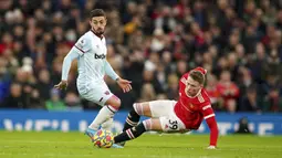 Pemain Manchester United Scott McTominay (kanan) kehilangan keseimbangan saat dia ditekel oleh pemain West Ham United Manuel Lanzini pada pertandingan sepak bola Liga Inggris di Stadion Old Trafford, Manchester, Inggris, 22 Januari 2022. Manchester United menang 1-0. (AP Photo/Dave Thompson)