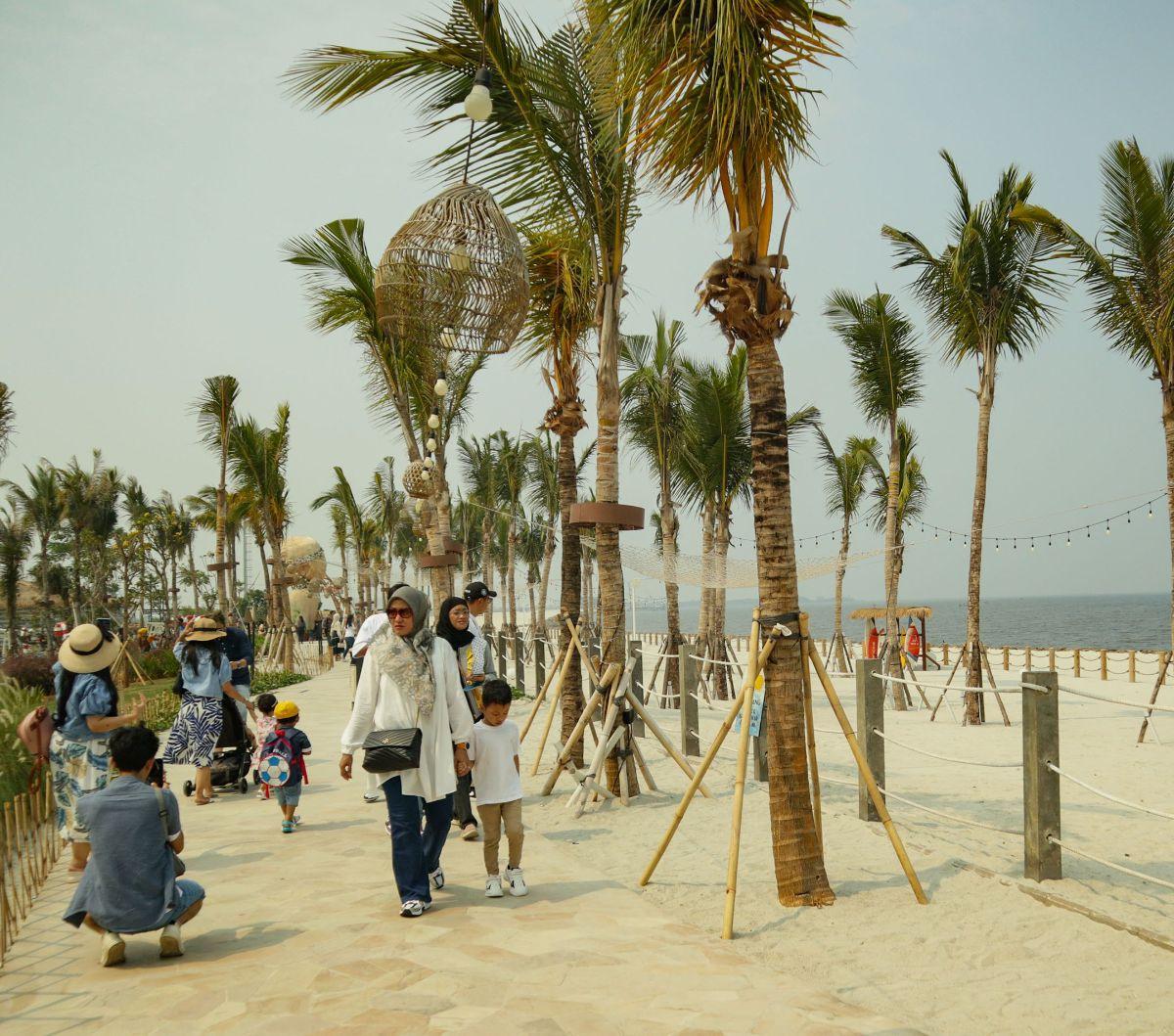 Wisatawan mengunjungi pantai pasir putih dan destinasi kuliner Aloha PIK di kawasan Pantai Indah Kapuk (PIK) 2, Tangerang, Banten, Senin (25/12/2023).&nbsp;Aloha PIK merupakan sebuah destinasi tematik baru yang berlokasi di pantai pasir putih sepanjang em