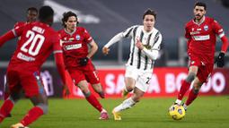 Pemain Juventus, Federico Chiesa, berusaha melewati pemain SPAL pada laga Coppa Italia di Stadion Allianz, Rabu (27/1/2021). Juventus menang dengan skor 4-0. (Fabio Ferrari/LaPresse via AP)