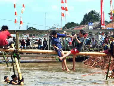Peserta mengikuti lomba gebuk bantal di Kalimalang, Jakarta Timur, Senin (17/8). Lomba tersebut dalam rangka menyemarakkan perayaan HUT RI ke-71.(Liputan6.com/Johan Tallo)