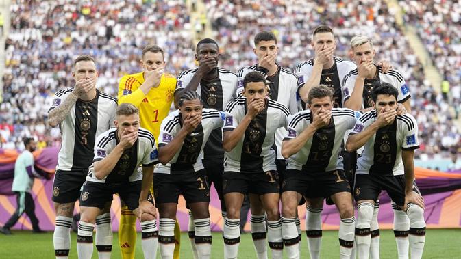 Pemain Timnas Jerman berpose untuk foto tim dengan menutupi mulut mereka dalam pertandingan Grup E Piala Dunia 2022 melawan Jepang, di Stadion Internasional Khalifa di Doha, Qatar, Rabu (23/11/2022). (AP Photo/Ebrahim Noroozi)