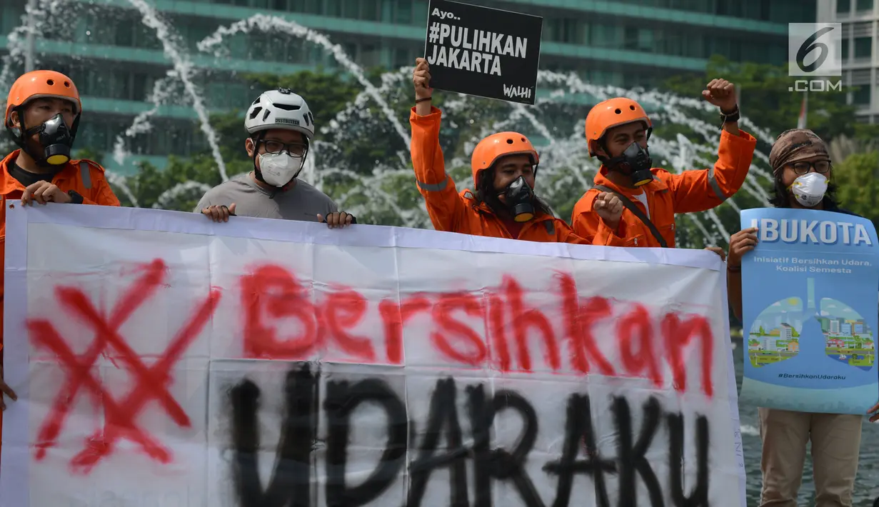 Aktivis membentangkan spanduk saat kampanye damai terkait buruknya udara Jakarta di Bundaran HI, Rabu (5/12). Dalam aksinya, mereka mengimbau kepada warga sekitar untuk sadar dan berpartisipasi memperbaiki kualitas udara Jakarta. (Merdeka.com/Imam Buhori)