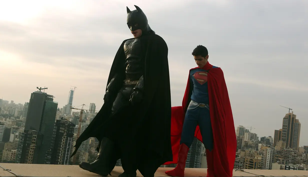 Dua orang pria mengenakan kostum Batman dan Superman saat sesi pemotretan di Lebanon (23/3). Fenomena Batman vs Superman menjadi perhatian para pecinta superhero karena film terbarunya yang muncul. (PATRICK BAZ / AFP)