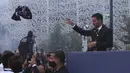 Lionel Messi melempar jersey tim ke pendukung Paris Saint-Germain (PSG) di luar stadion Parc des Princes di Paris pada Rabu (11/8/2021). Messi dikontrak oleh PSG selama dua tahun dengan opsi perpanjangan setahun di klub kaya Paris itu. (AP Photo/Rafael Yaghobzadeh)