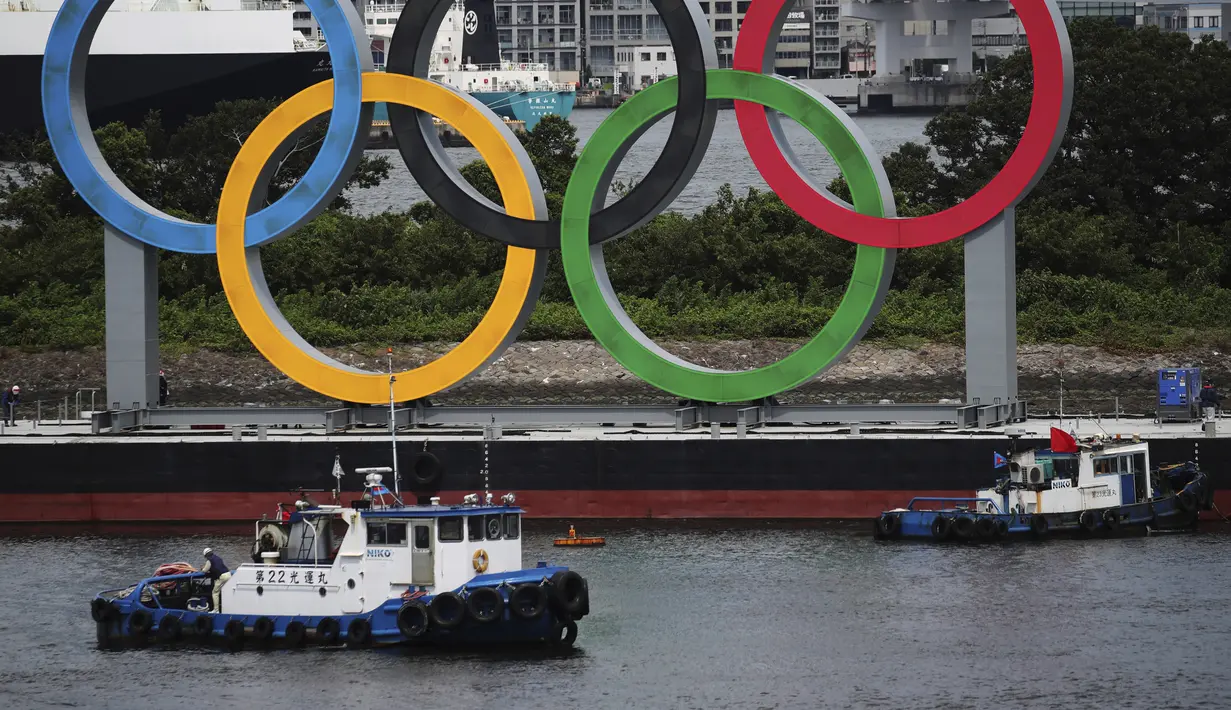 Kapal bersiap untuk menarik cincin Olimpiade saat dipindahkan dari area tepi laut di Taman Laut Odaiba setelah Olimpiade Musim Panas 2020 berakhir pada 8 Agustus di Tokyo, Rabu (11/8/2021). Setelah ini, Kota Paris akan menjadi tuan rumah olimpiade pada 2024 mendatang. (Kim Kyung-Hoon/Pool via AP)
