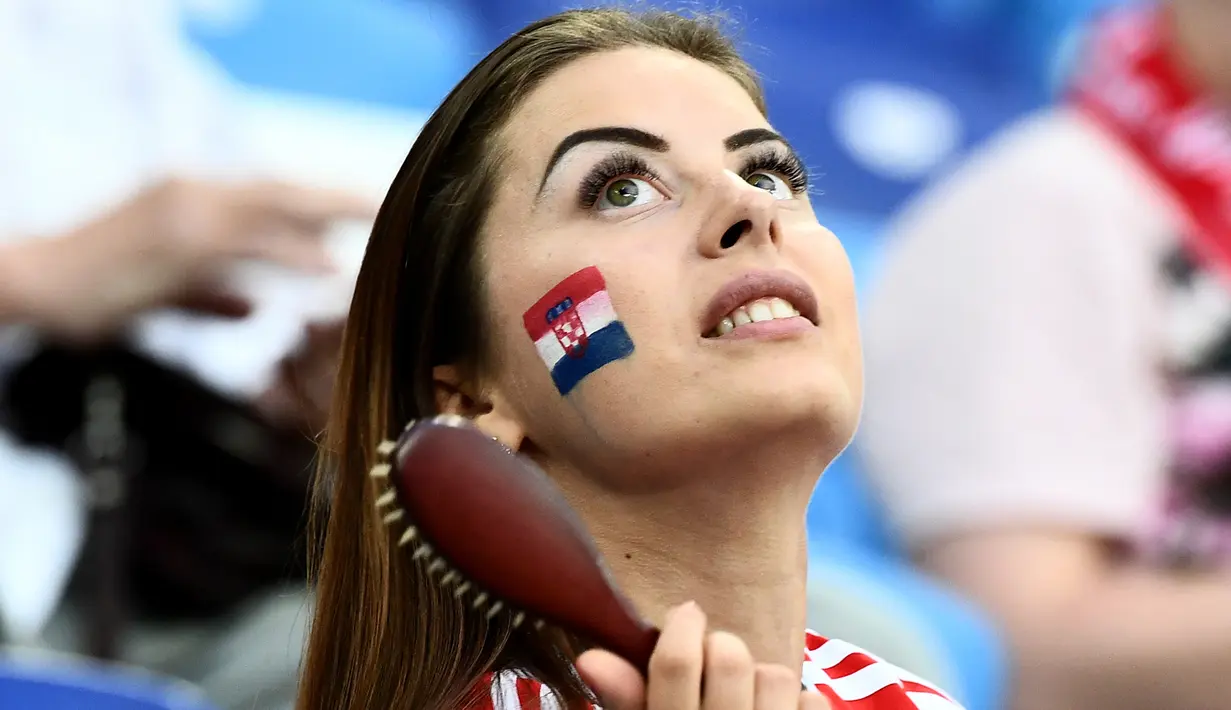 Suporter wanita Kroasia menyisir rambutnya sambil menunggu pertandingan antara Kroasia melawan Denmark pada 16 besar Piala Dunia 2018 di Nizhny Novgorod Stadium, Rusia (1/7). Kroasia berhasil mengalahkan Denmark lewat adu penalti. (AFP Photo/Jewel Samad)